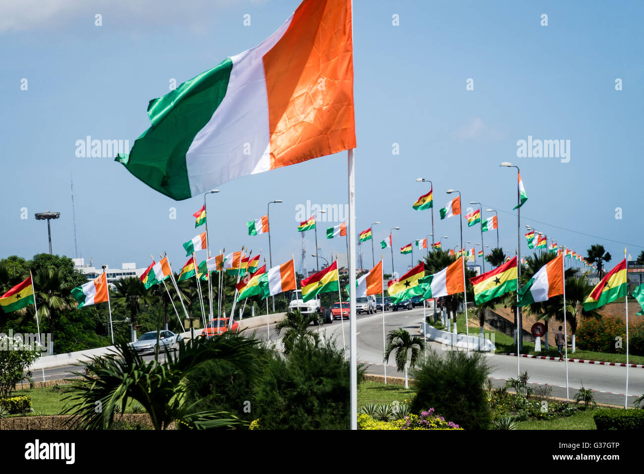 Flag of Côte d'Ivoire or Ivory Coast (foreground). Mix of flags of Côte d'Ivoire and Ghana seen in background. Stock Photo