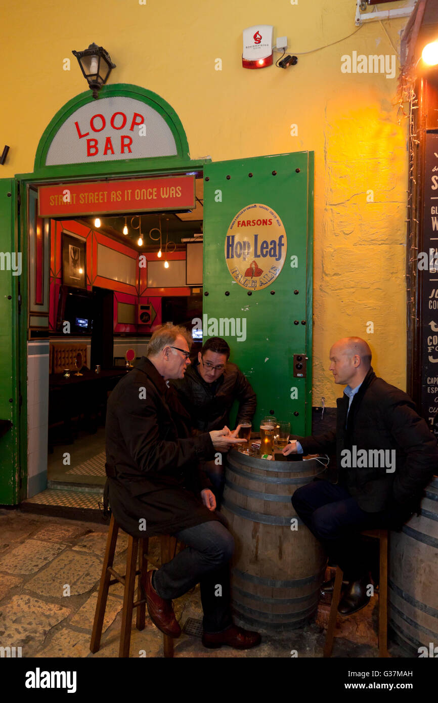 People drinking in the alleyway outside a retro bar in Strait Street in Valletta. Stock Photo