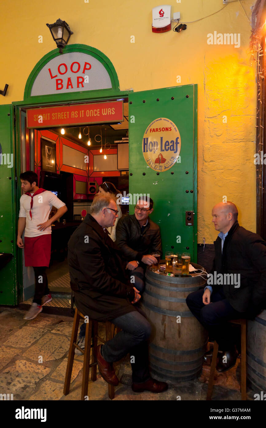 People drinking in the alleyway outside a retro bar in Strait Street in Valletta. Stock Photo