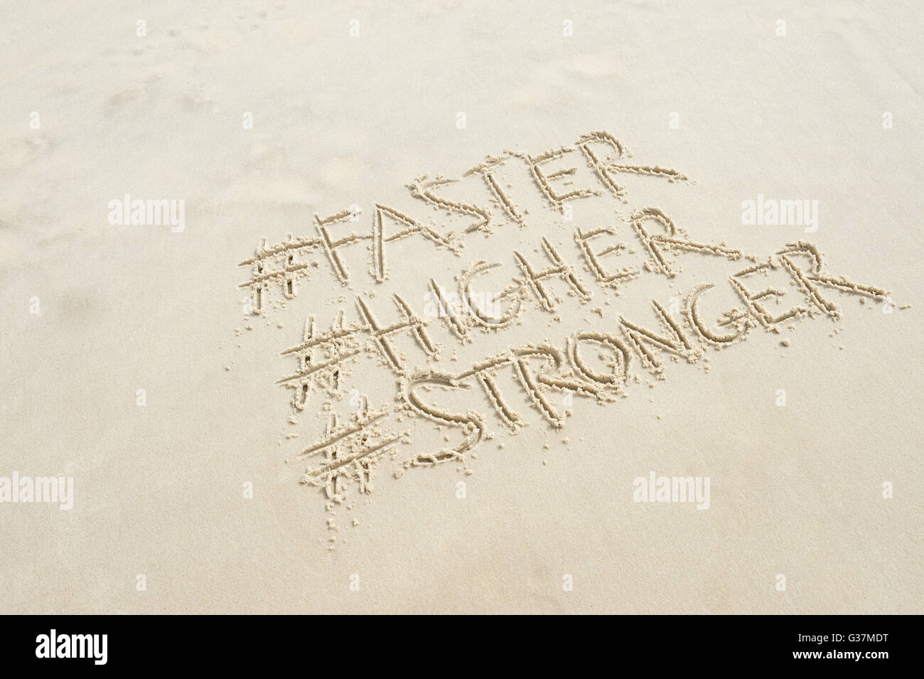 RIO DE JANEIRO - MARCH 20, 2016: The Olympic motto, Faster, Higher, Stronger, introduced at the 1924 Games in Paris, in sand. Stock Photo