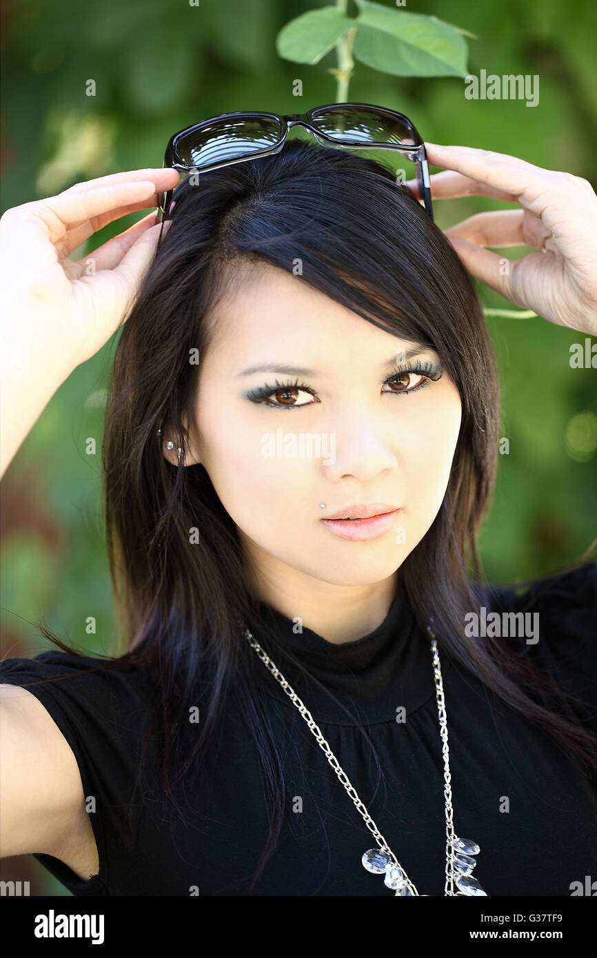 Young woman outdoor portrait with sunglasses on top of head Stock Photo