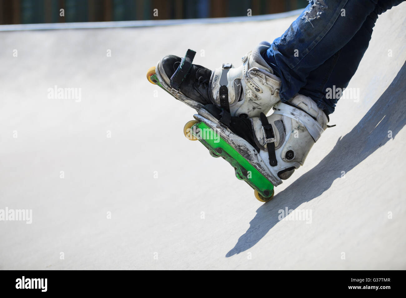 Feet of rollerblader wearing aggressive inline skates sitting on a