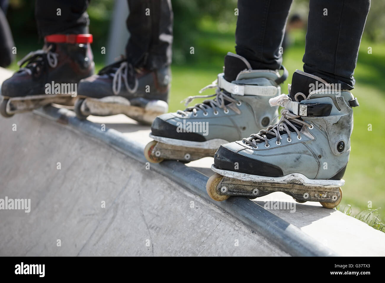 Feet of rollerblader wearing aggressive inline skates standing on top