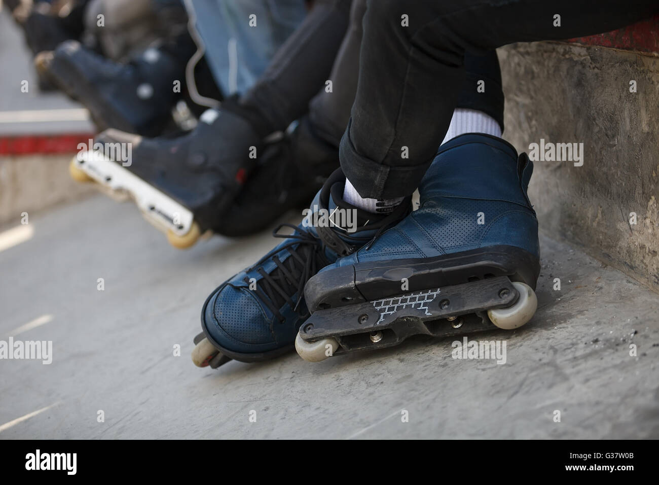 Feet of rollerblader wearing aggressive inline skates sitting on a