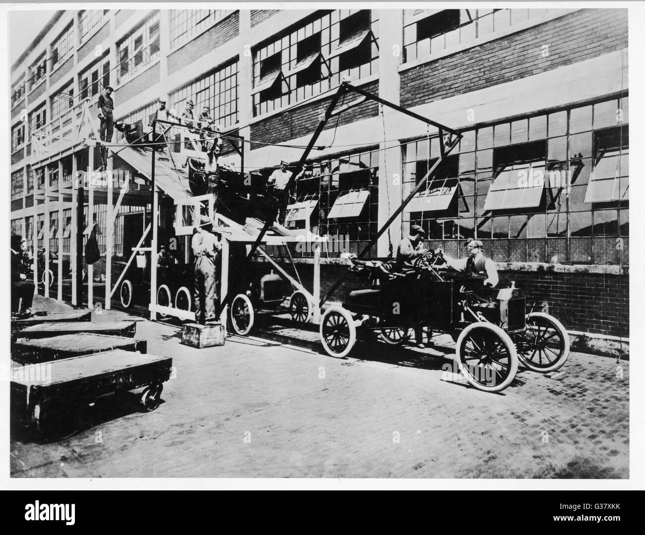 Working on the Ford assembly line in Detroit, USA. Here, car bodies are united with the chassis.     Date: 1909 Stock Photo