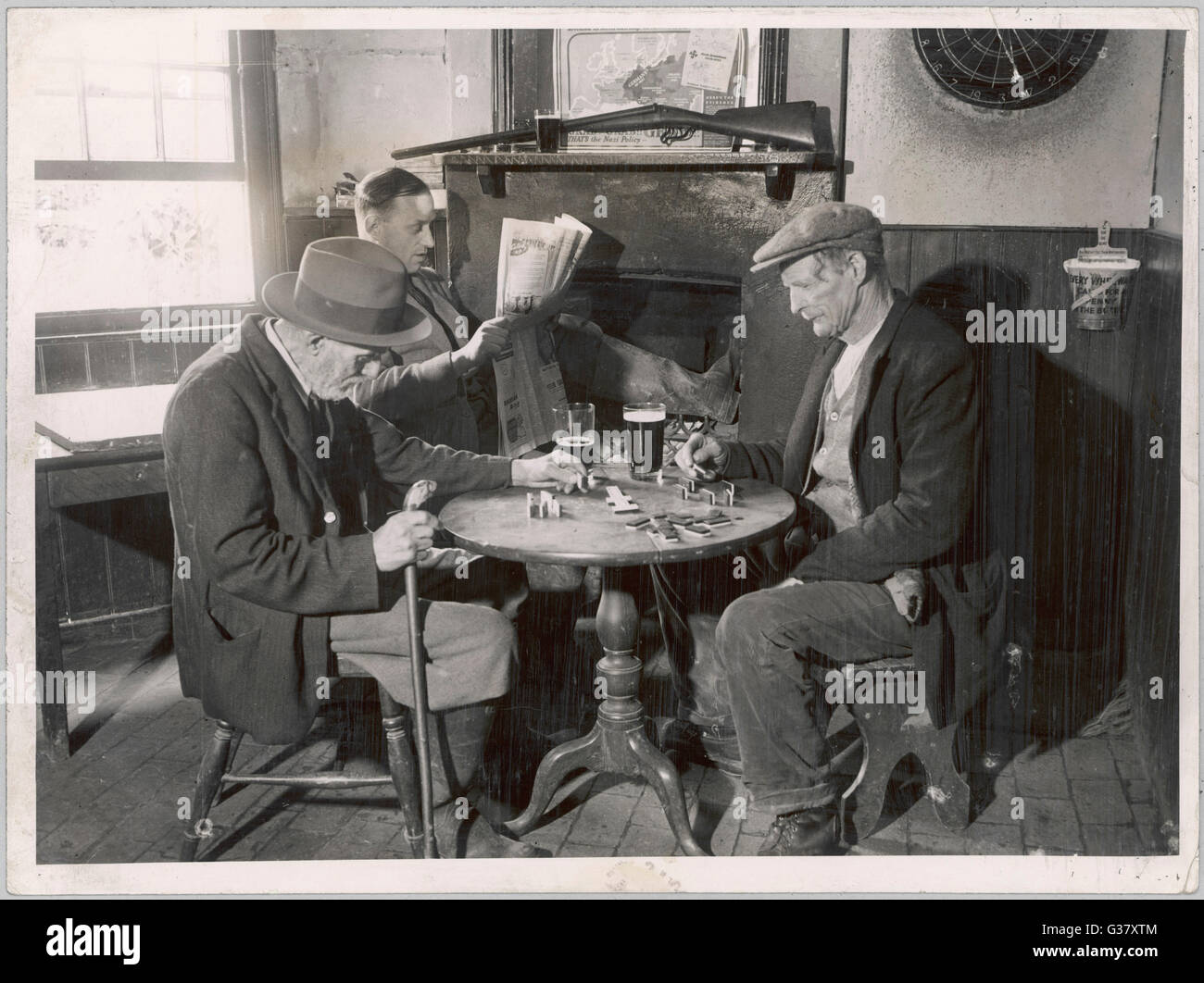 A game of dominoes in an English country pub.     Date: 1930s Stock Photo