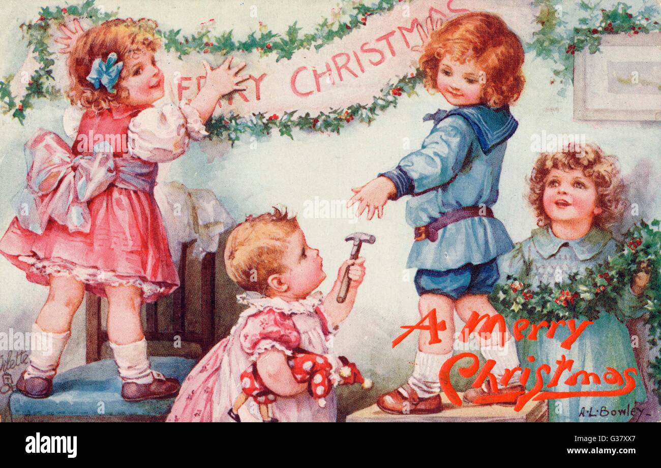 Christmas decorations: children hang up a festive banner Stock Photo