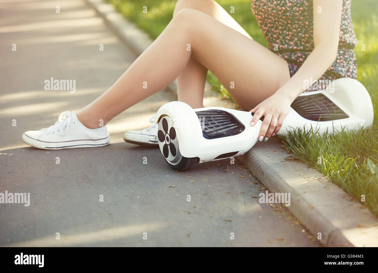 Female with electric mini hover board scooter in green park. Eco city transportation on battery power, produce no air pollution to atmosphere Stock Photo