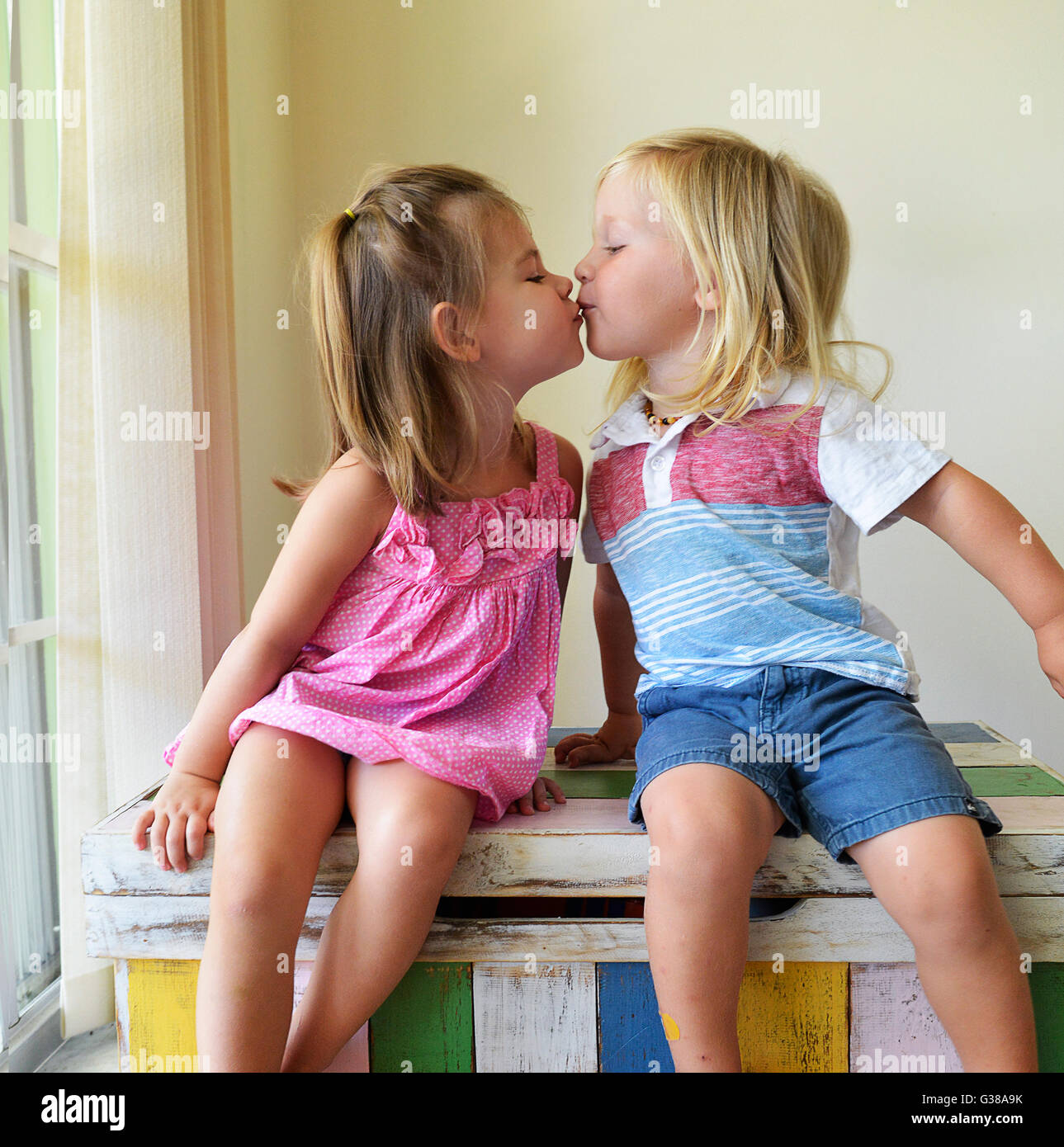 Toddler boy and girl kissing Stock Photo