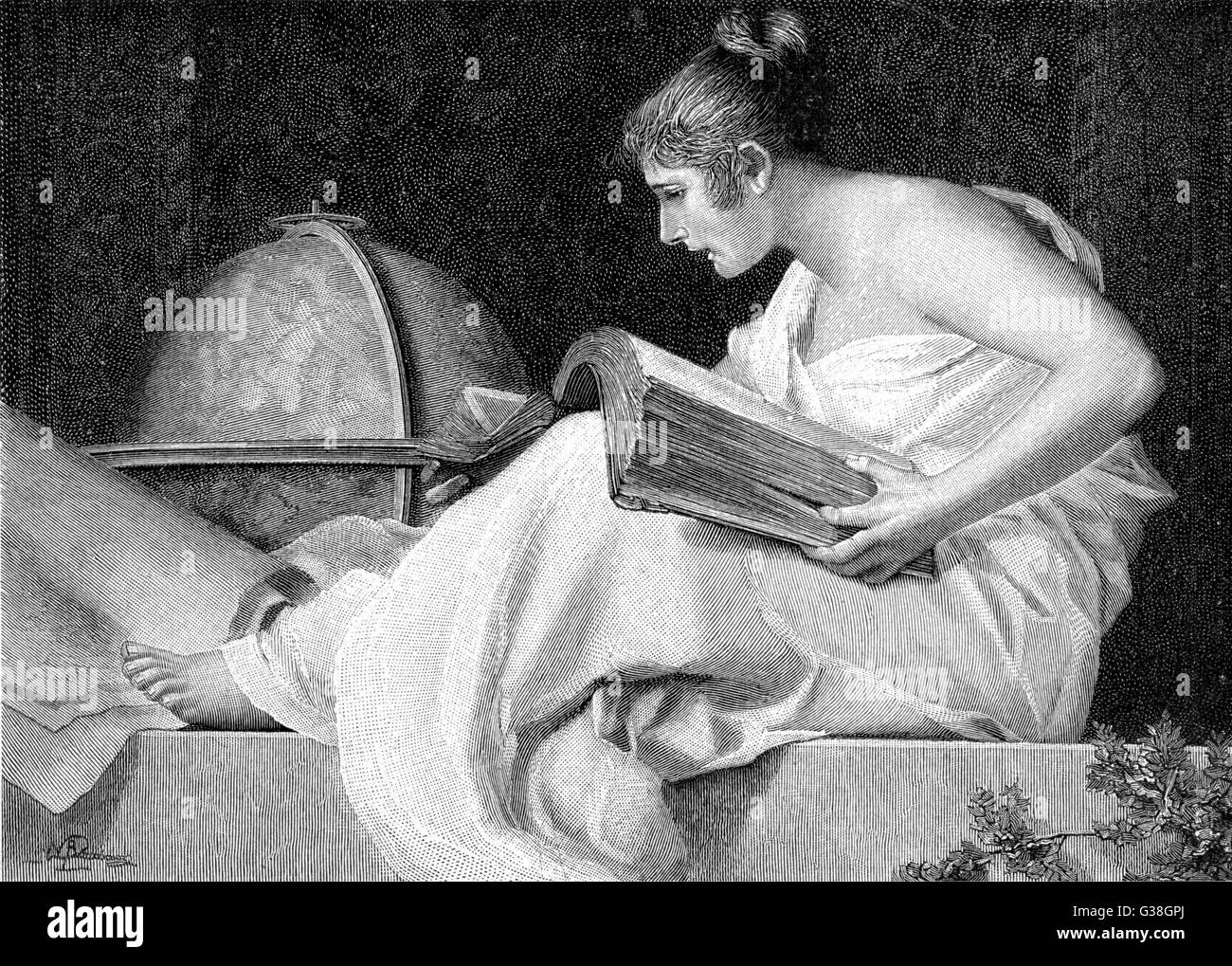 A lady with her feet up reads  a heavy book. Stock Photo