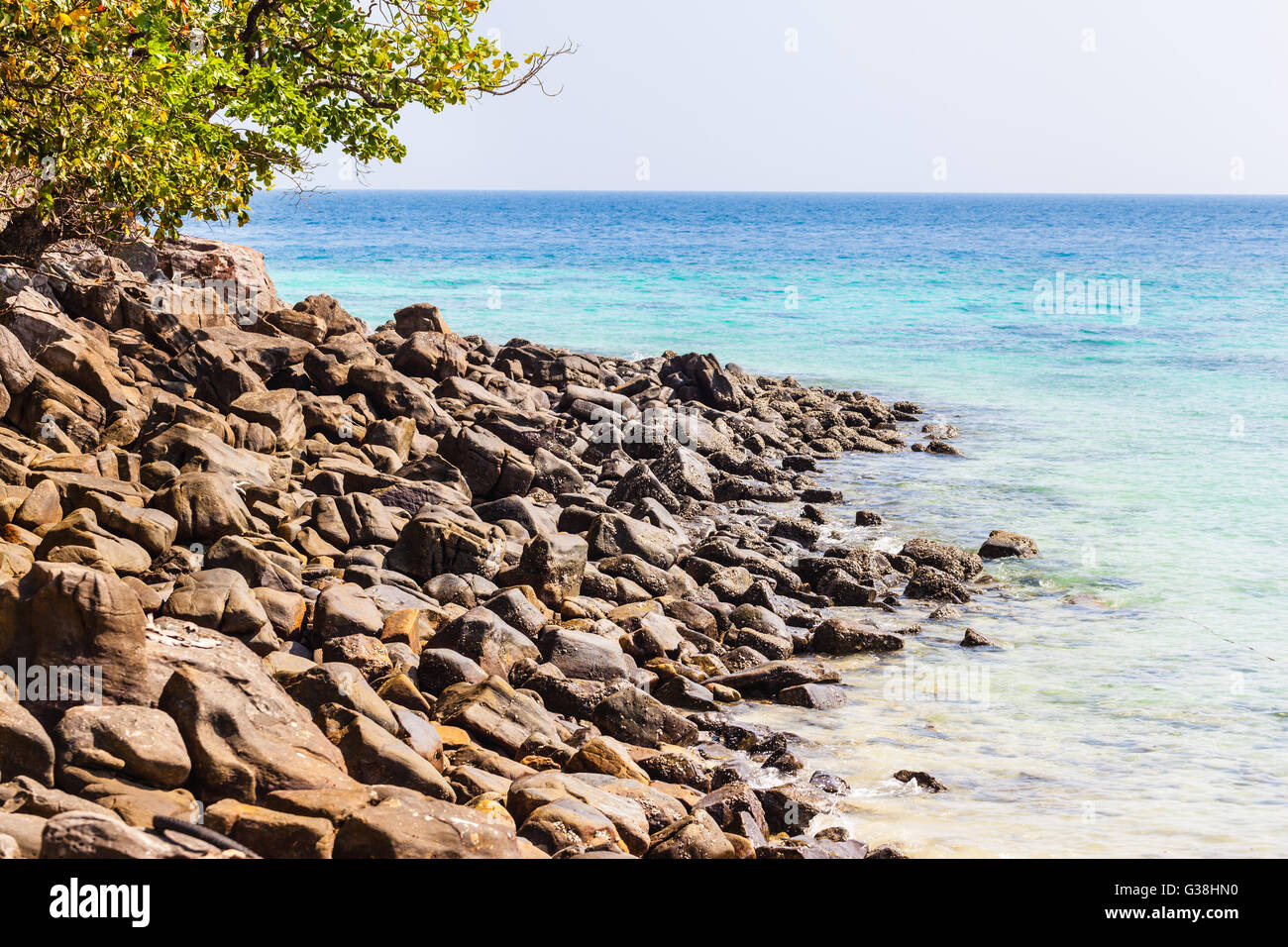 a rocky beach in a tropical island with vibrant azure sea Stock Photo