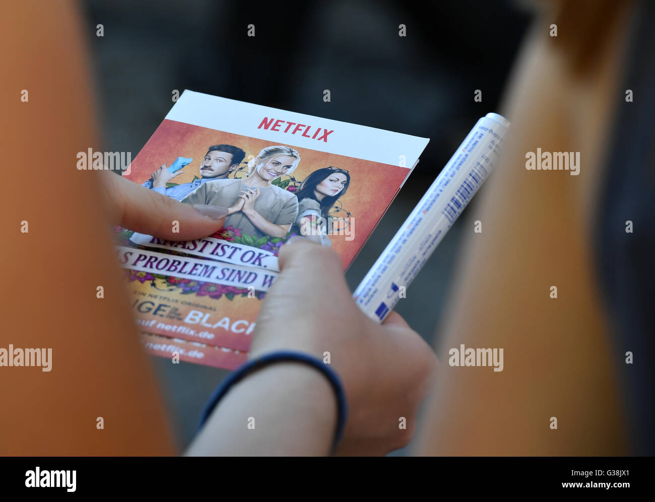 Fans wait with flyers by streaming provider Netflix in their hands at the premiere of the Netflix series 'Orange is the new Black - 4th series' in Berlin, 7 June 2016. Netflix is the worldwide leading subscription service for mobile streaming of movies and series. Photo: Jens Kalaene/dpa Stock Photo