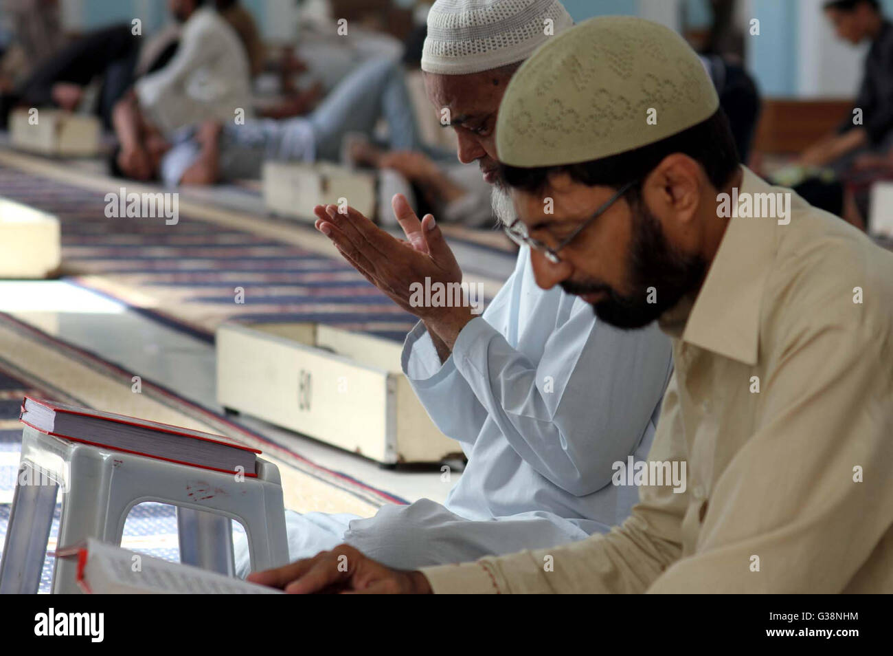 Muslims reciting Holy Quran after Zohar prayer as they are Fasting during the holy month on Ramzan, at Jama Masjid Memon in Karachi on Thursday, June 09, 2016. Stock Photo