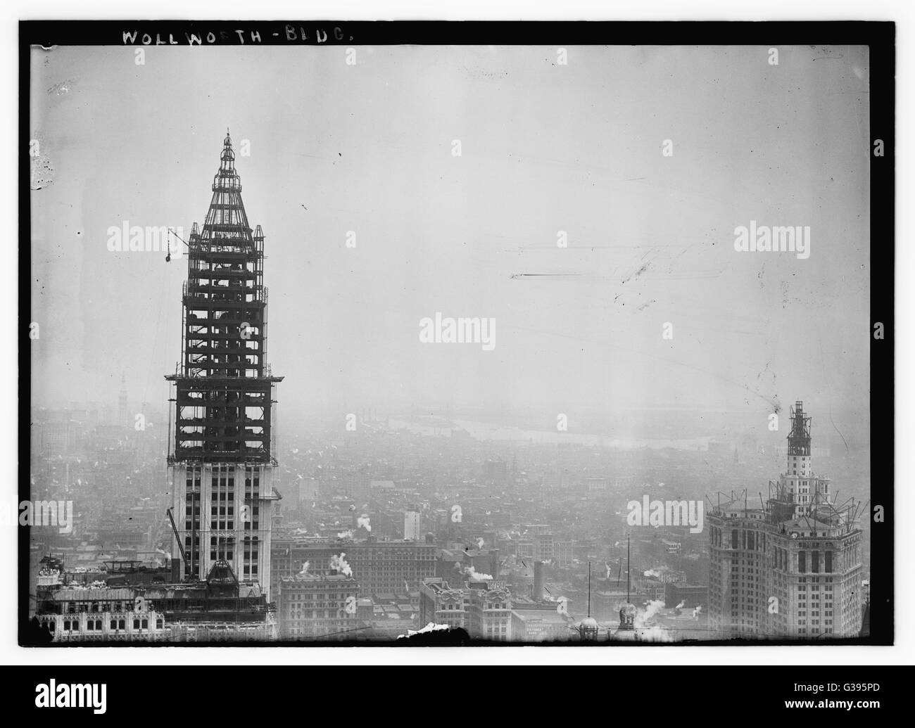 The tower construction for the Woolworth Building on Broadway, New York City, which was completed in April 1913. On the right is the Municipal Building, also under construction, with the East River in the background. Stock Photo