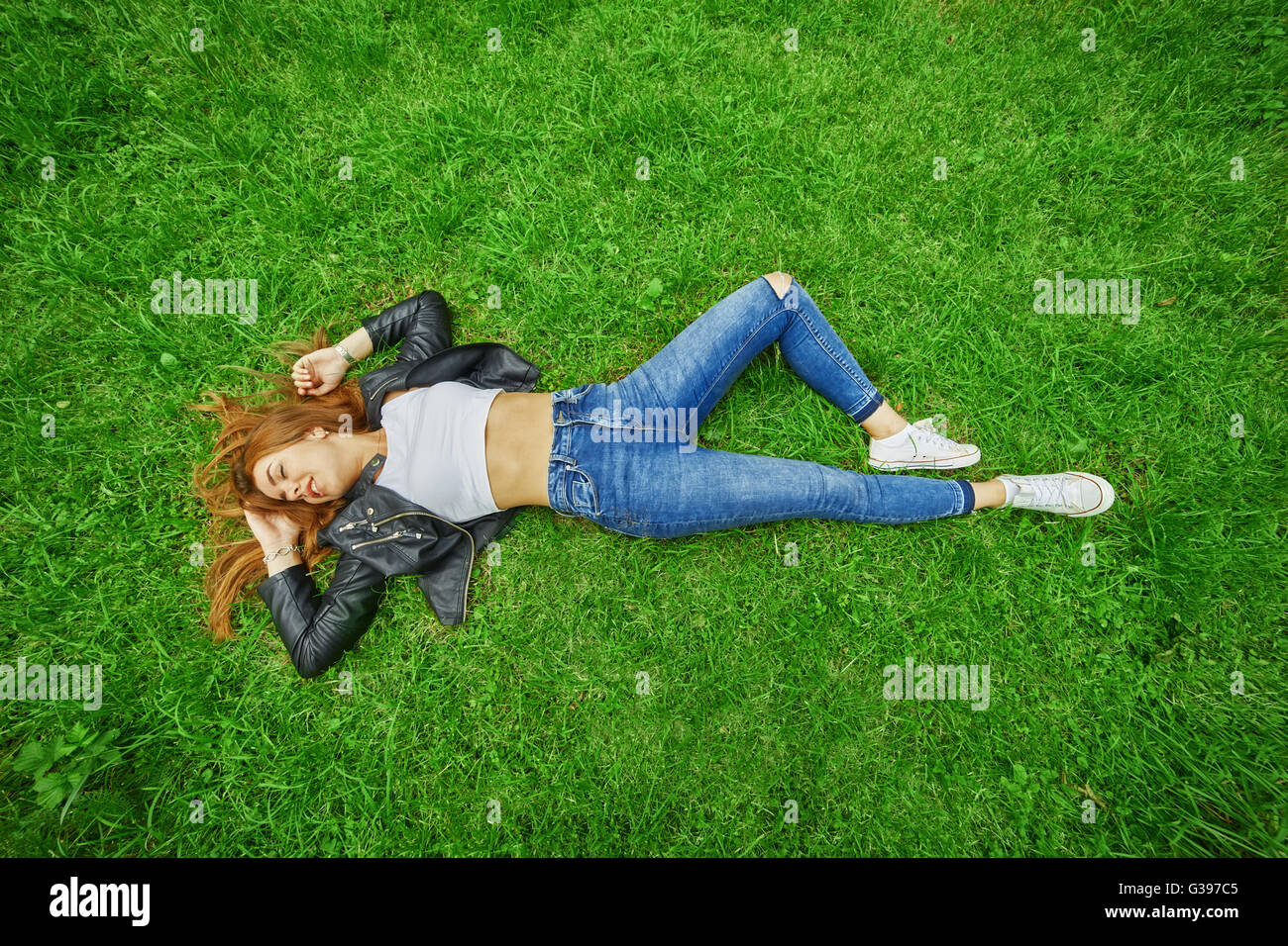 happy girl lying on green grass Stock Photo - Alamy