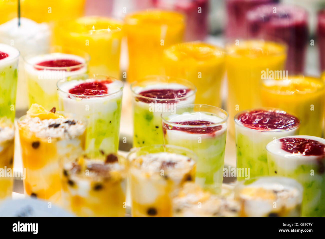 Frozen fruit smoothies with fresh blended different fruits served in tall glasses, summer sweet