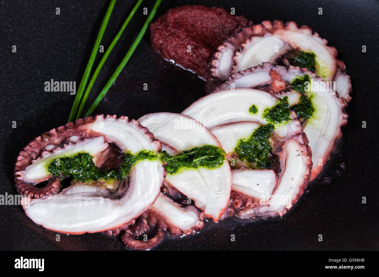 Octopus carpaccio on black dish Stock Photo