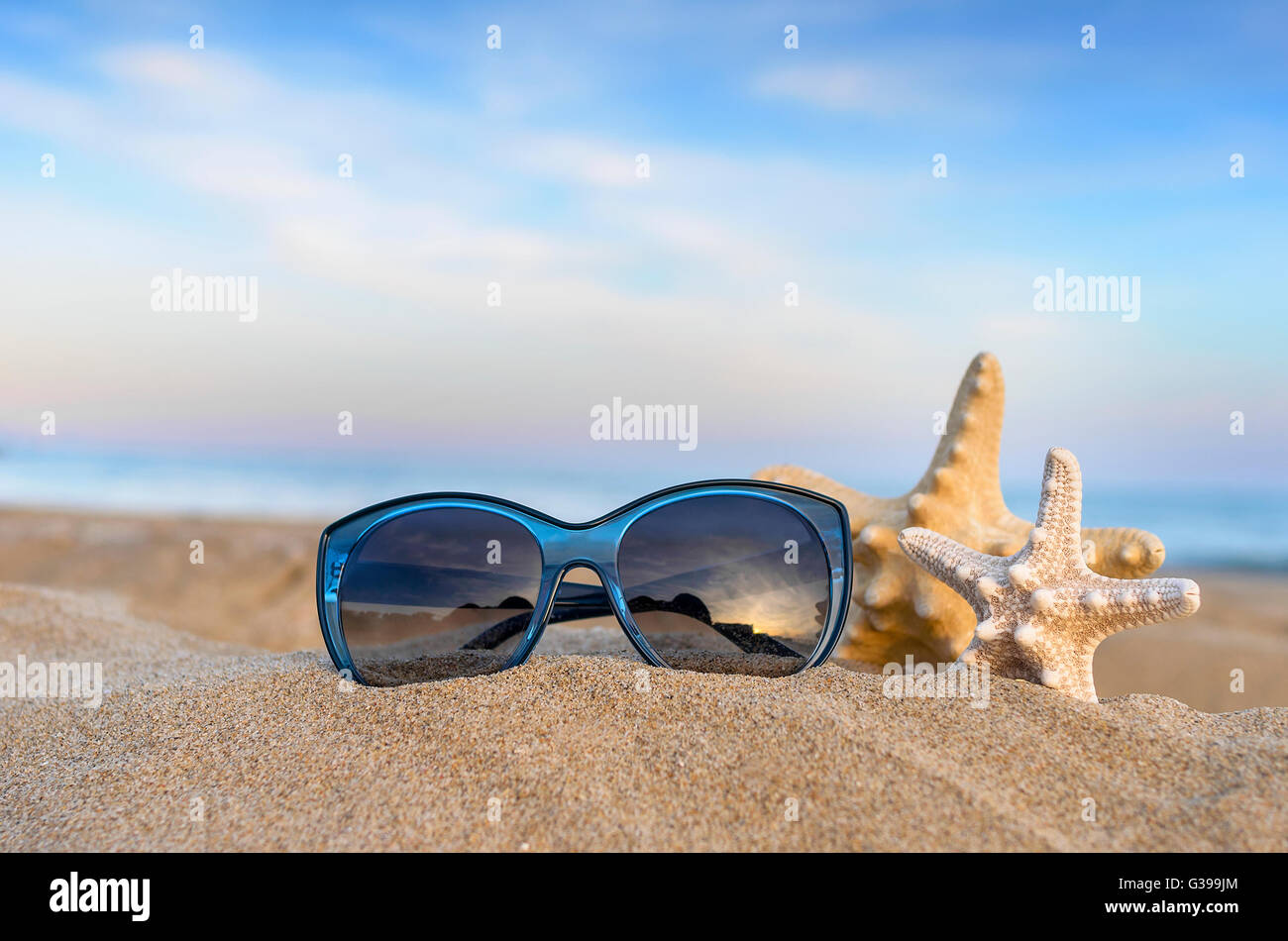 Marine still life. Flip flops, sunglasses and starfish on sea and sky ...
