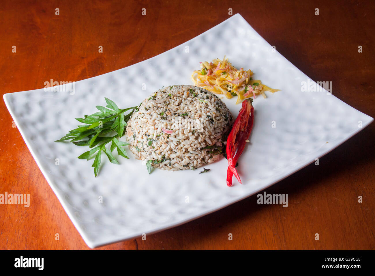 Nasi kerabu or herbed rice with condiments Stock Photo