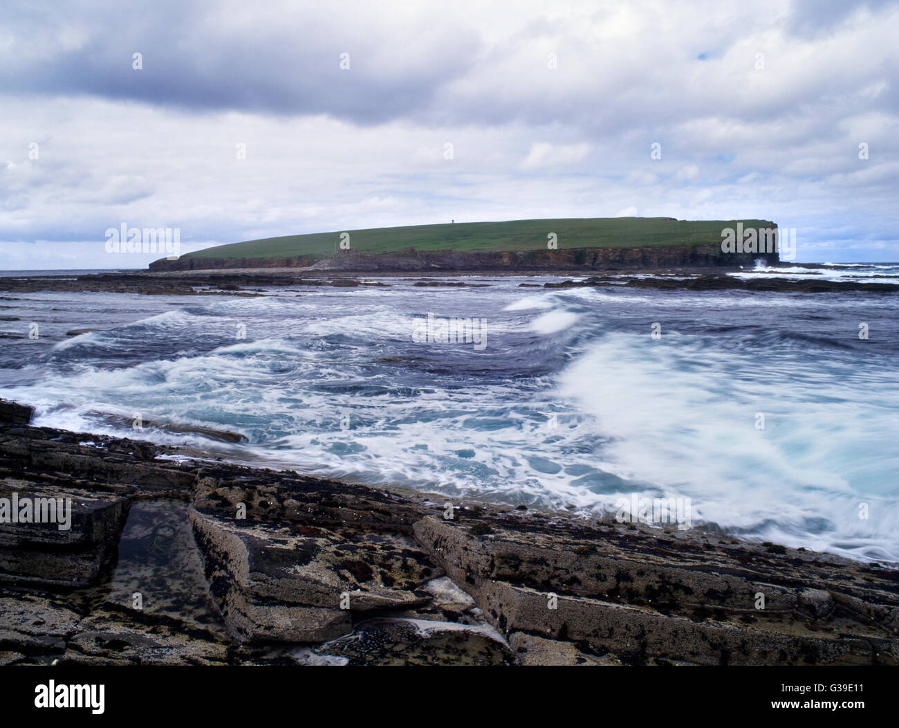 View W from Point of Buckquoy on the NW of Mainland, Orkney, to the tidal island of the Brough of Birsay Viking-age site with incoming tide. Stock Photo
