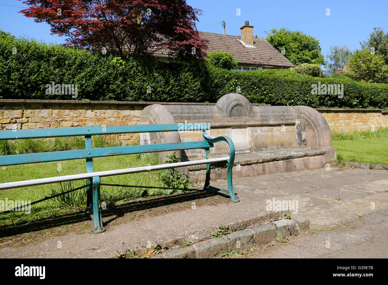 An ancient stone seat and more modern bench in an English village