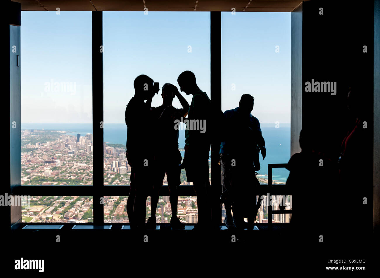 Silhouette of people photographing Chicago with their mobile 'phones from the observation deck of the Willis Tower. Stock Photo