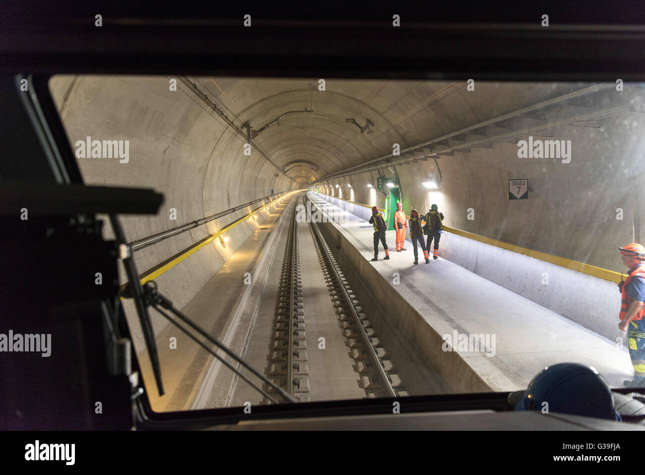 People pictured from a train during a media orientation on the test operation of the Gotthard Base Tunnel in Erstfeld in the Canton of Uri, Switzerland, on March 10, 2016. The Gotthard Base Tunnel consists of two 57-kilometres-long single-track tubes. It joins the north portal in Erstfeld with the south portal in Bodio. On January 16, 2016, SBB Cargo took up test drives with cargo trains for AlpTransit, the owner. The tests will continue until the end of May 2016, the inauguration of the Gotthard Base Tunnel takes place on June 1, 2016, and the tunnel will be taken into regular operation in De Stock Photo