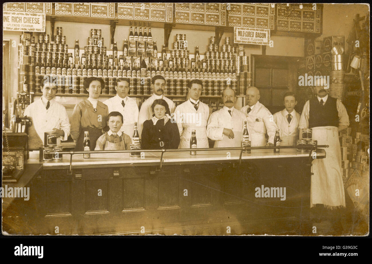 The staff of the Co-Op grocery store lined up behind the counter       Date: c1915 Stock Photo