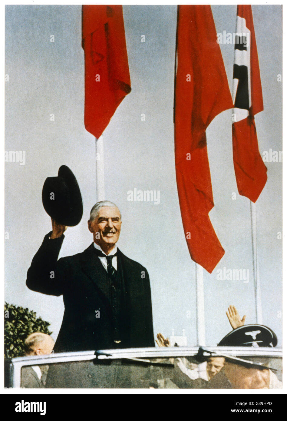 British Prime Minister, Neville Chamberlain (1869-1940), waves from an open-top car, shortly after arriving in Munich for a meeting with Adolf Hitler over threats to invade Czechoslovakia.      Date: 29th September 1938 Stock Photo