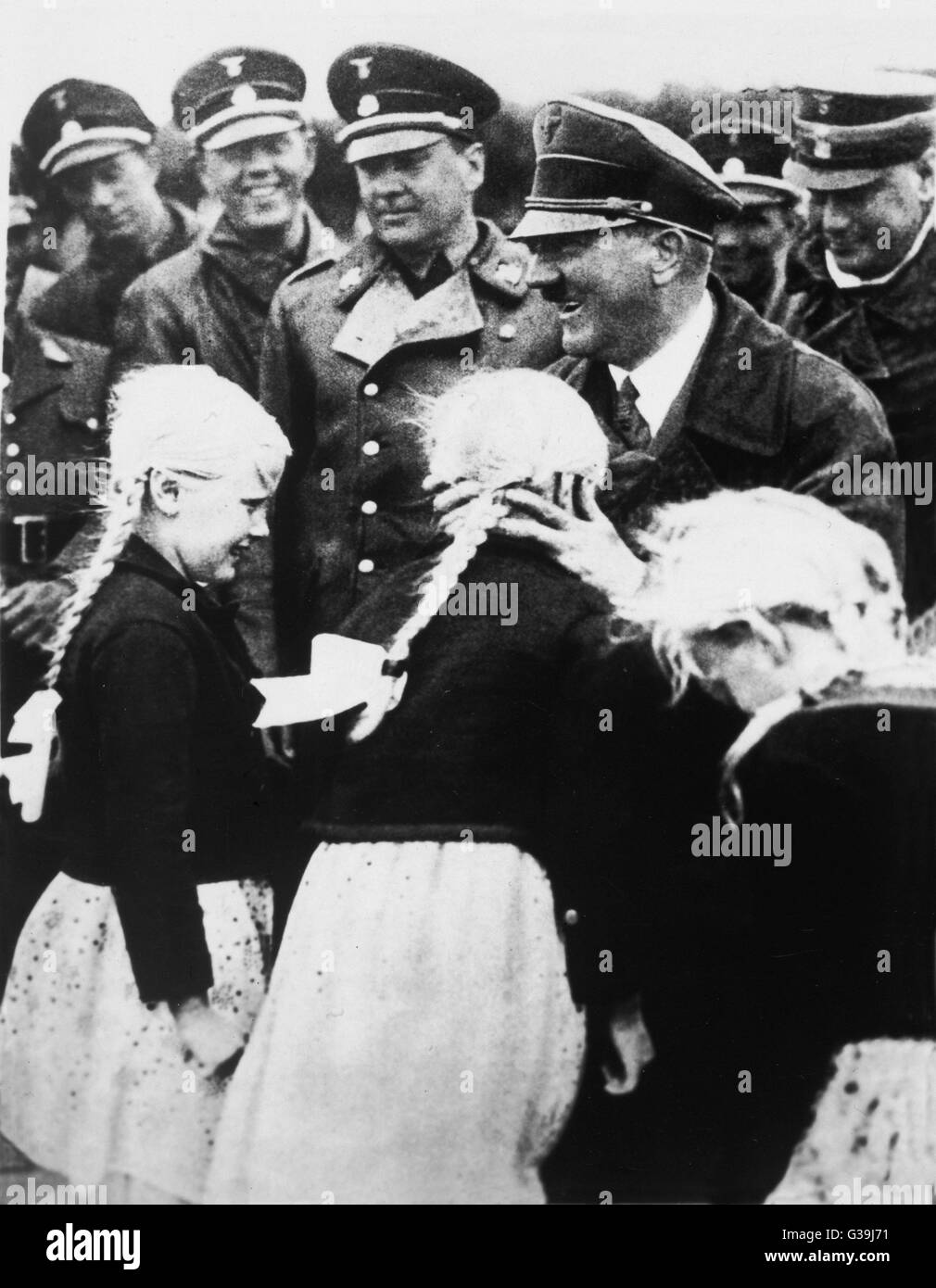 HITLER Hitler as presented by Nazi  propaganda under the Third  Reich. Seen here greeting  Ayran-styled little girls Stock Photo
