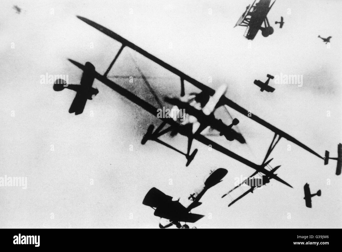Many bi-planes, silhouetted  against the sky, take part in  an aerial dogfight.  This image was one of a series of faked photographs which caused a sensation on publication in 1933. They accompanied the apparent diary of a World War One British pilot. Pre Stock Photo