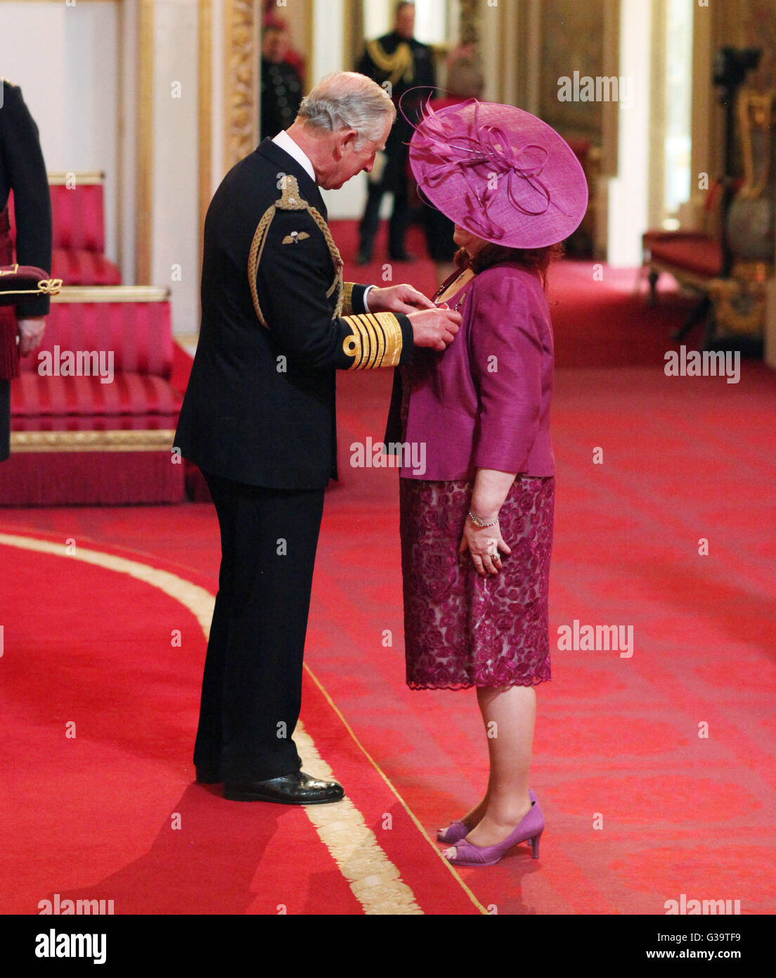 Mrs Janet Burns from Great Wyrley, receives an MBE (Member of the Order of the British Empire) by the Prince of Wales during an investiture ceremony at Buckingham Palace, London. Stock Photo