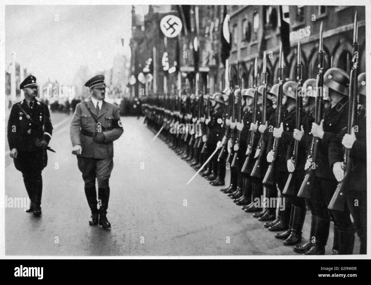 ADOLF HITLER  Inspecting troops at the  Nuremberg Parteitag in 1935 with Heinrich Himmler     Date: 1935 Stock Photo