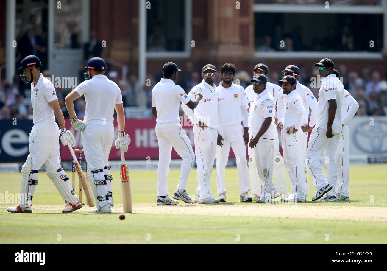 England's Alastair Cook (left) walks off after being dismissed by Sri Lanka's Nuwan Pradeep during day one of the Investec Third Test match at Lord's, London. Stock Photo