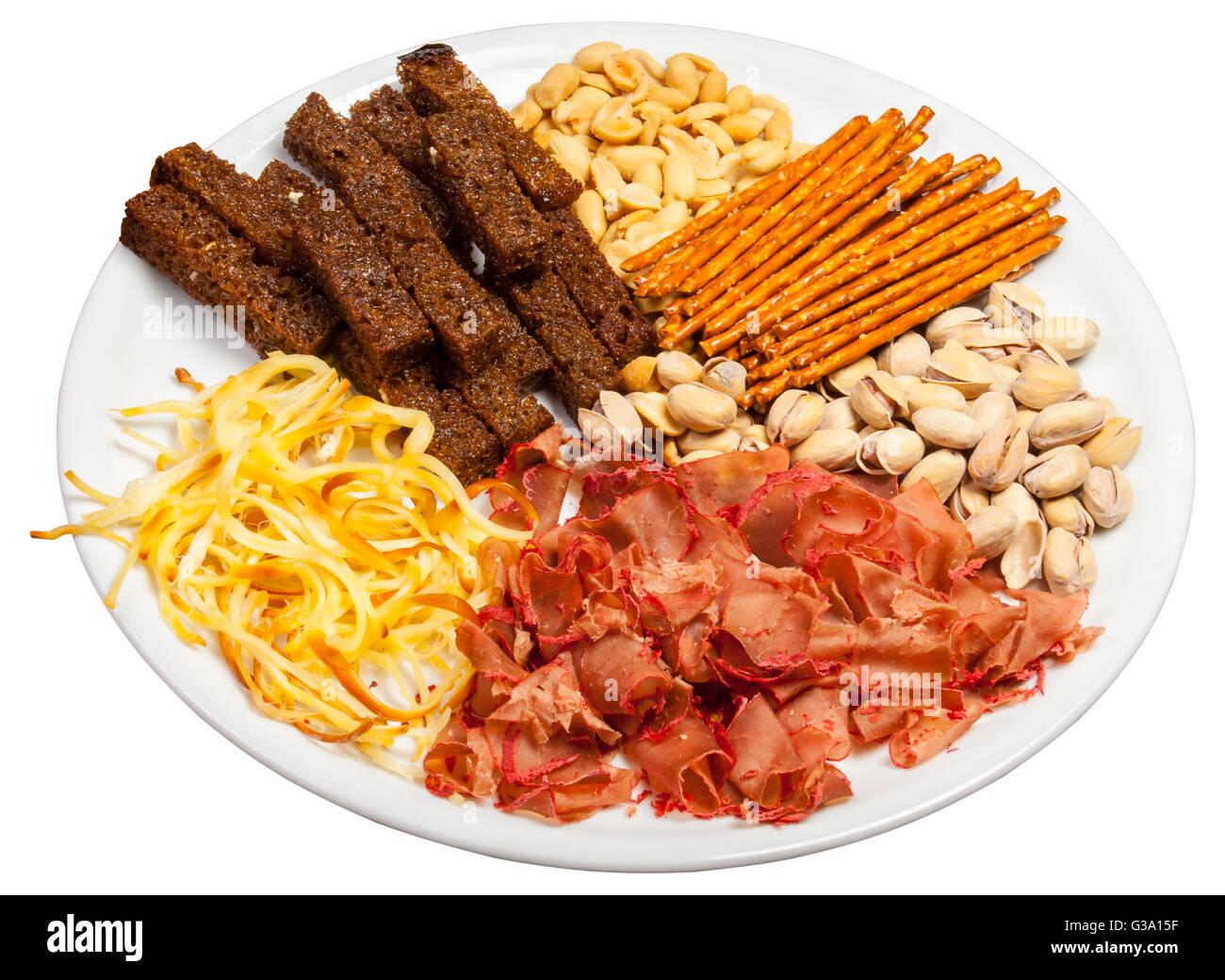 Plate full of crunchy, salty snacks, peanuts, pistachio nut cheese and meat Stock Photo