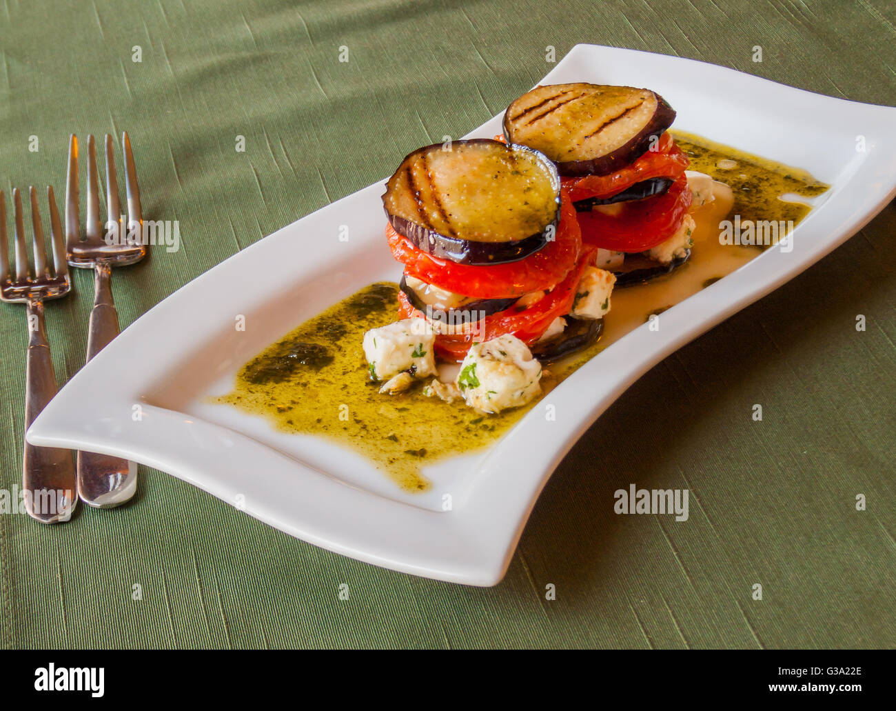 traditional italian crispy grilled eggplant with fresh tomatoes sliced​​, in olive sauce with cubes of Greek feta cheese Stock Photo