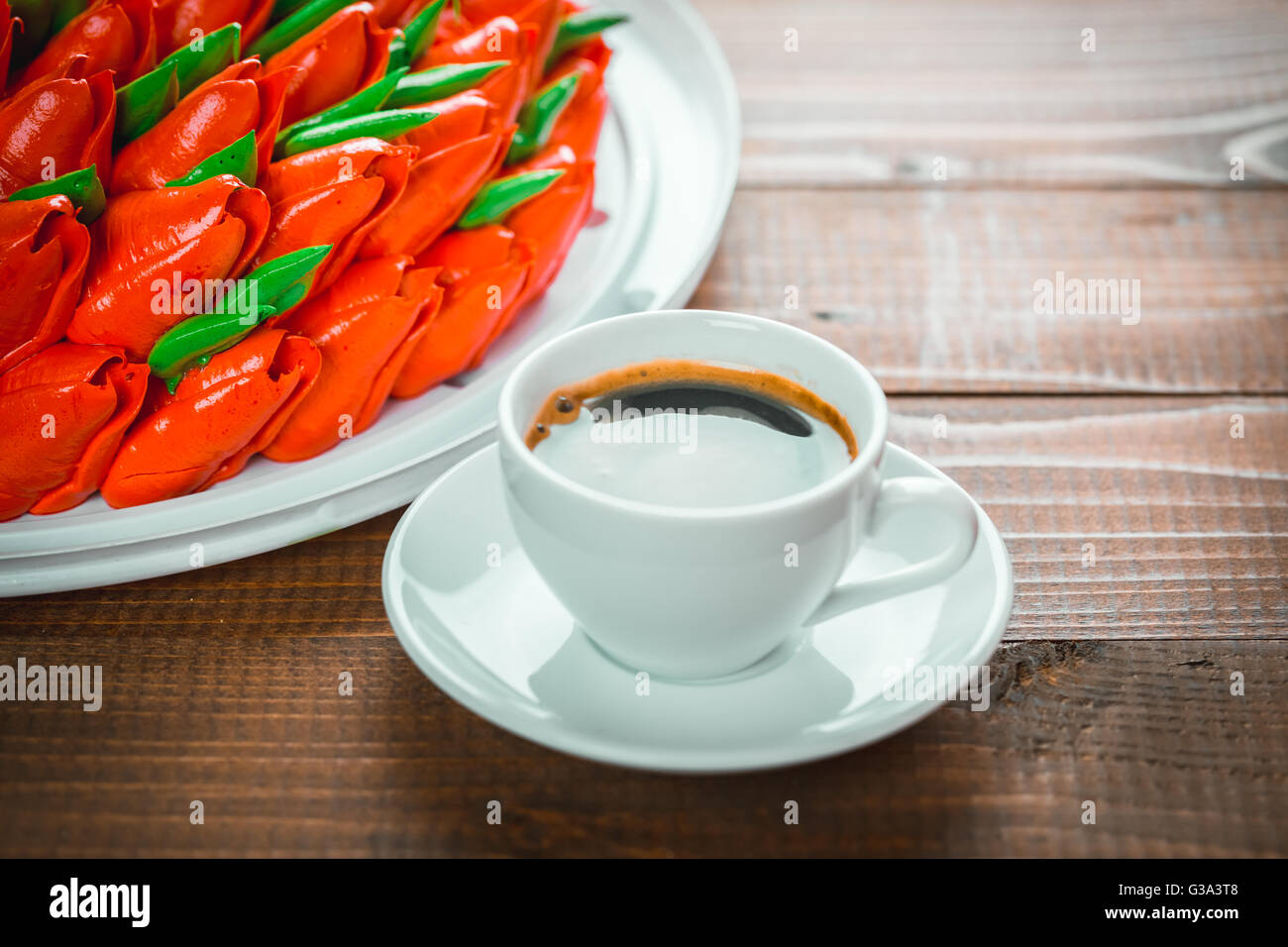Beautiful background with a Cup of hot coffee with foam and a birthday cake with flowers on wooden background Stock Photo