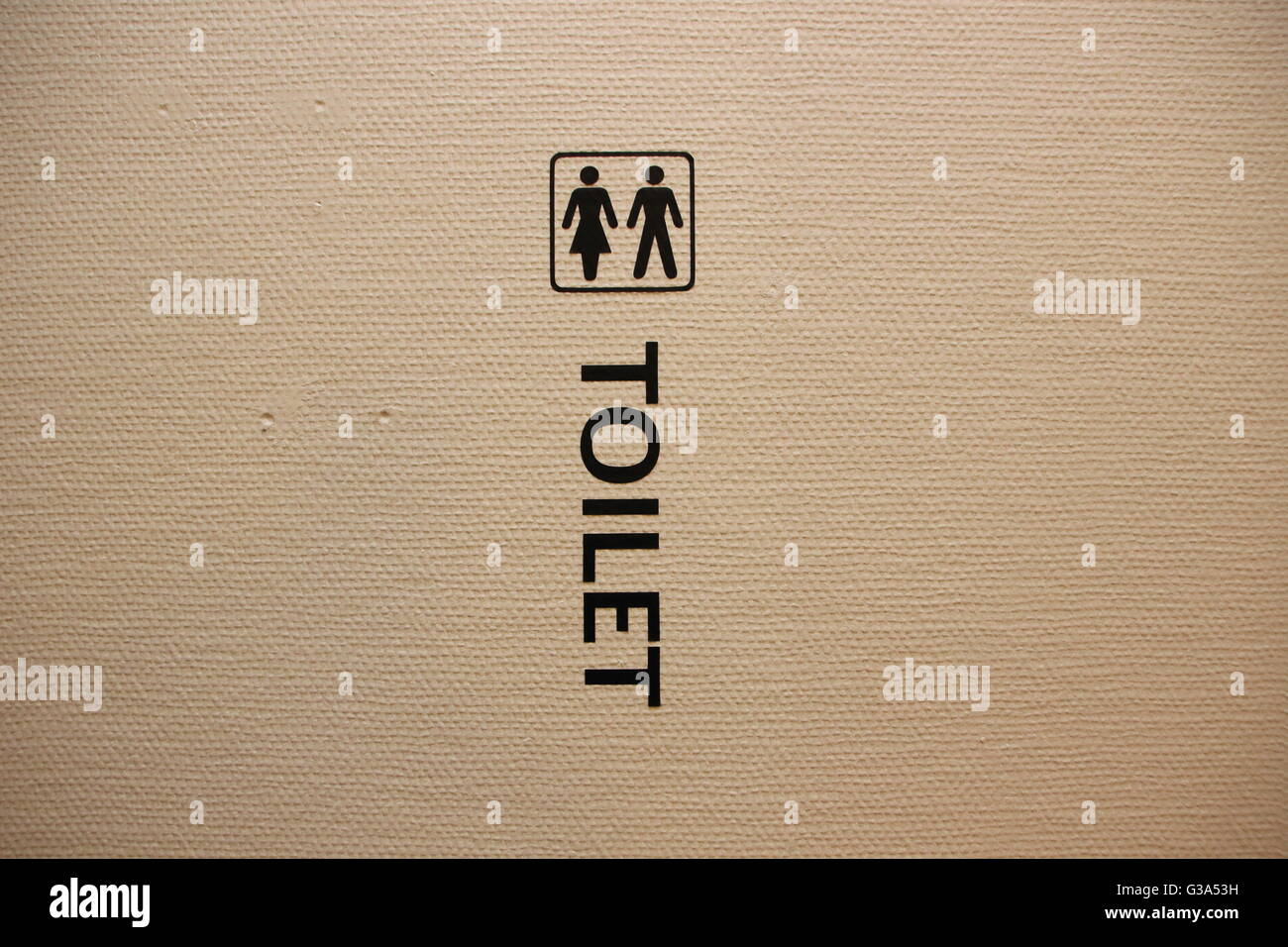 Man and Woman Toilet Sign on White Structured Wall Stock Photo