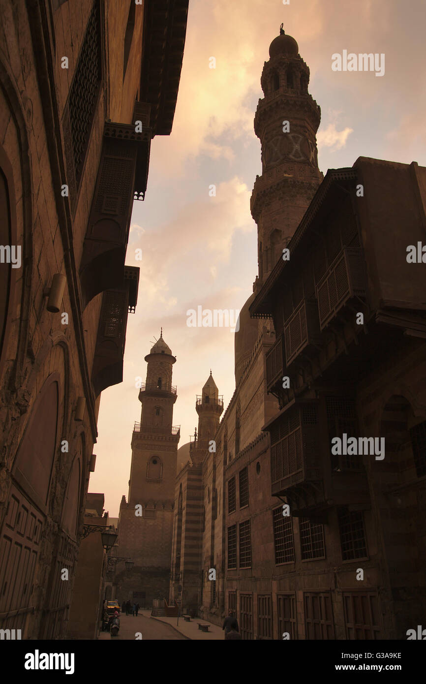 Minarets of Barquq complex (front), Madrasa an-Nasir Muhammad and Qalawun complex, Al-Muizz li-Din Allah street, dusk, Cairo Stock Photo