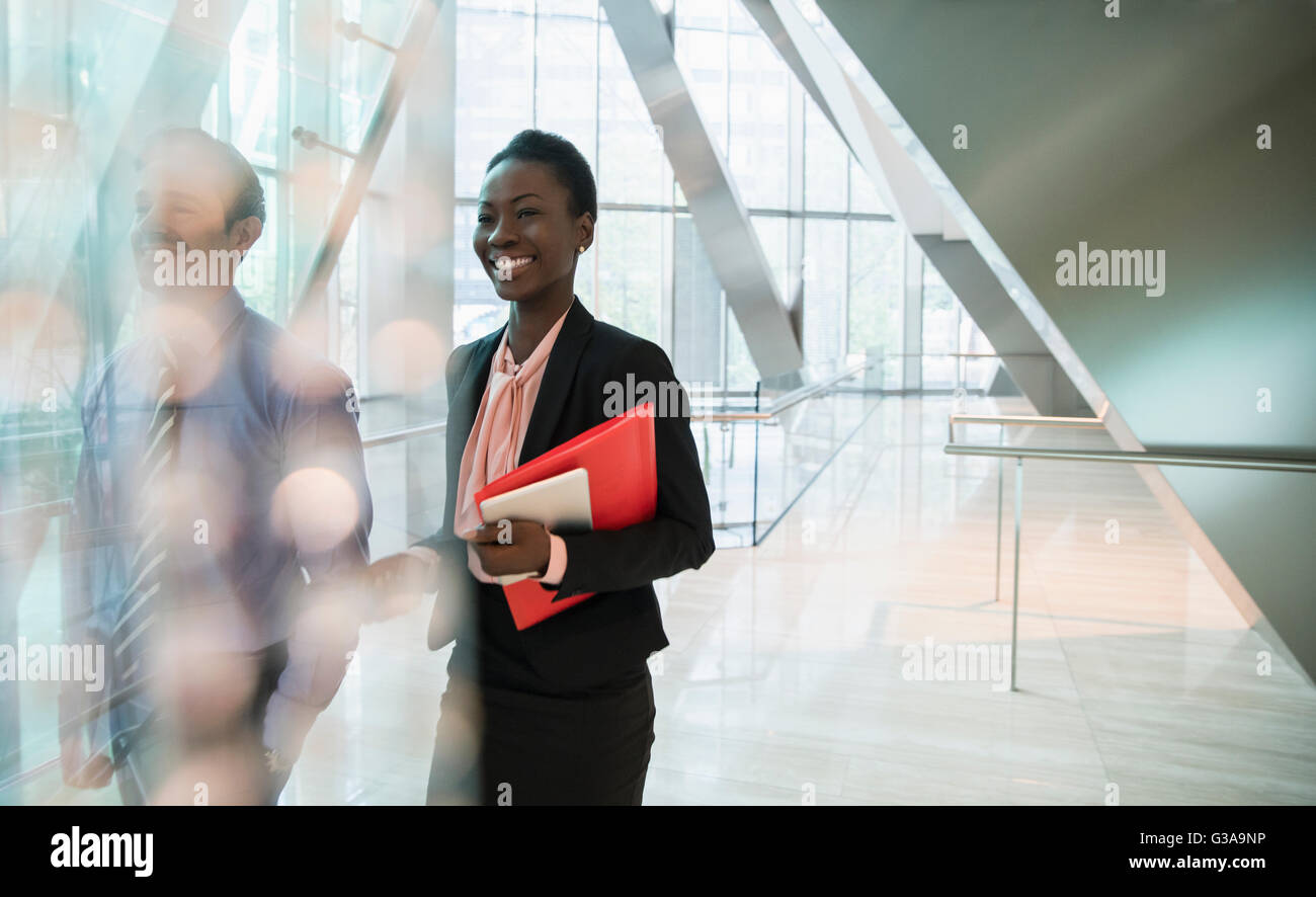 Smiling corporate businesswoman in modern office lobby Stock Photo