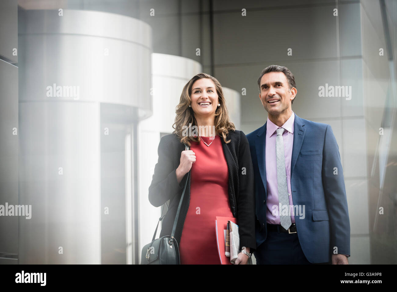 Smiling corporate businessman and businesswoman outside building Stock Photo