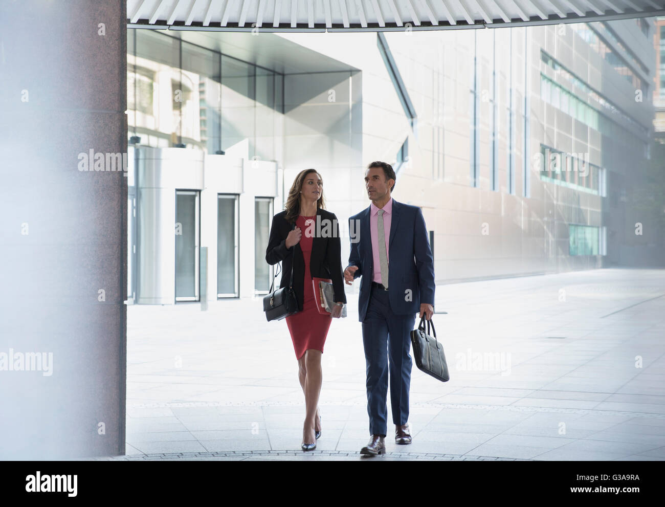 Corporate businessman and businesswoman walking outside building Stock Photo