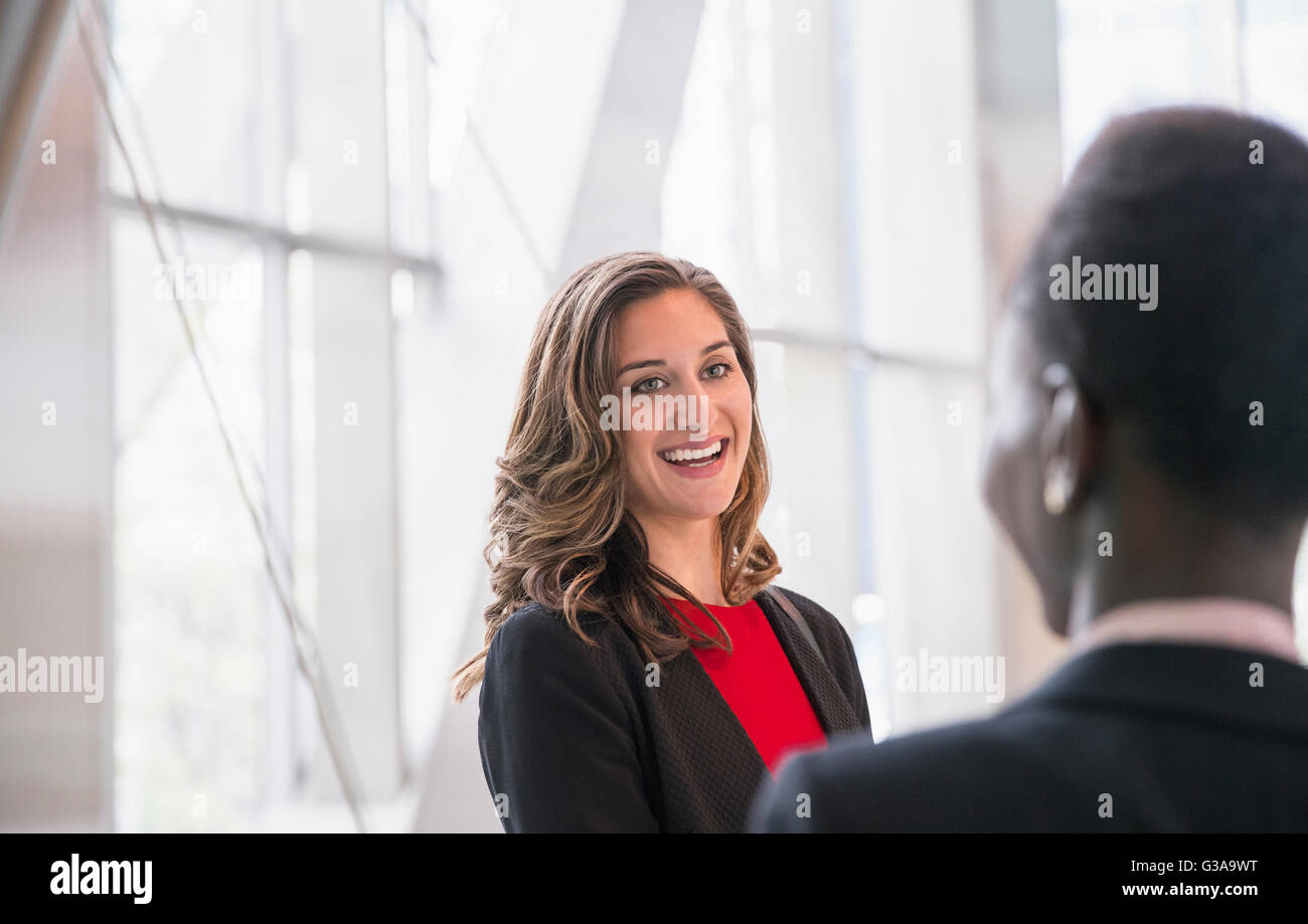 Smiling corporate businesswomen talking Stock Photo