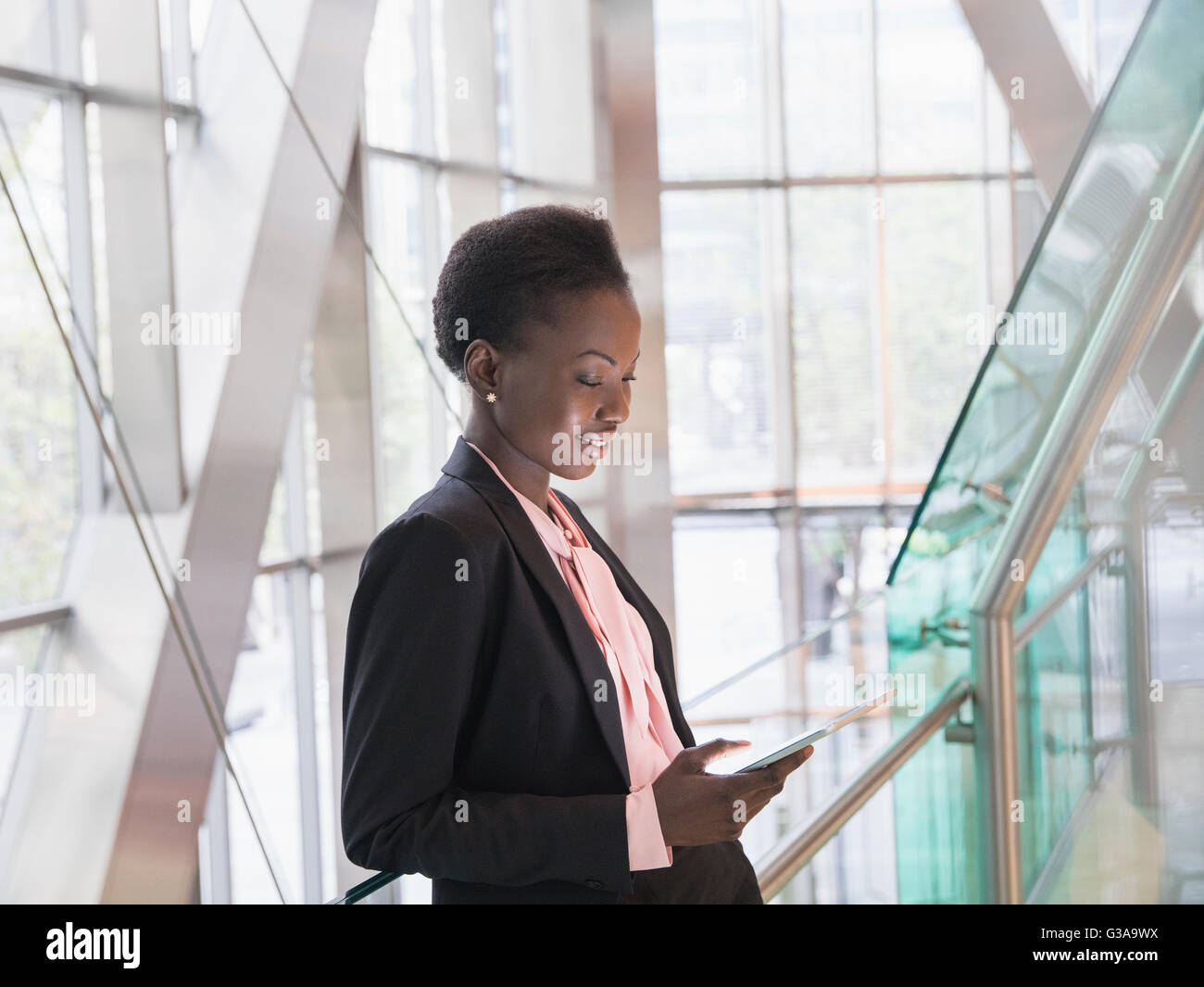 Corporate businesswoman using digital tablet in modern office lobby Stock Photo