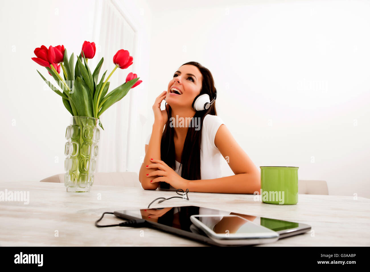 Portrait of a young beautiful woman listening to music with headphones ...