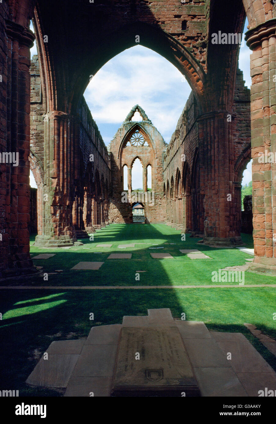 Looking W at the crossing & nave of Sweetheart Abbey church from the chancel: built of red Nithsdale sandstone. Founded by Lady Dervorgilla in 1273. Stock Photo