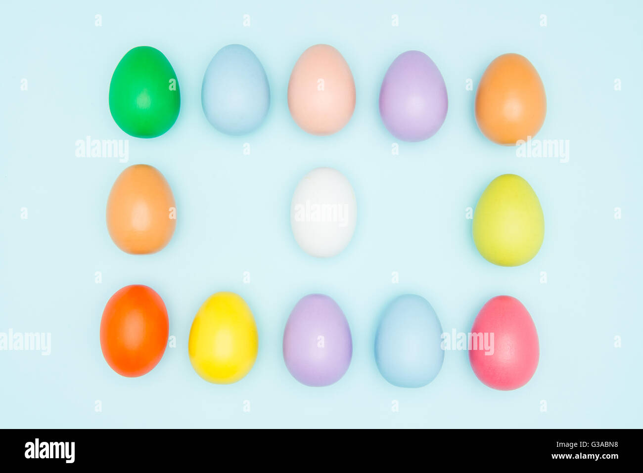Colorful easter eggs arranged in a square on pastel background, copy ...