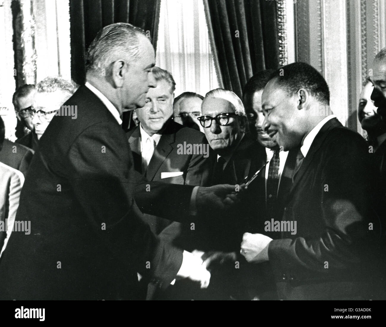 President Lyndon B. Johnson hands a souvenir pen to the Rev. Martin Luther King, Jr. after signing the Voting Rights Bill. The event took place at the Capitol. Stock Photo