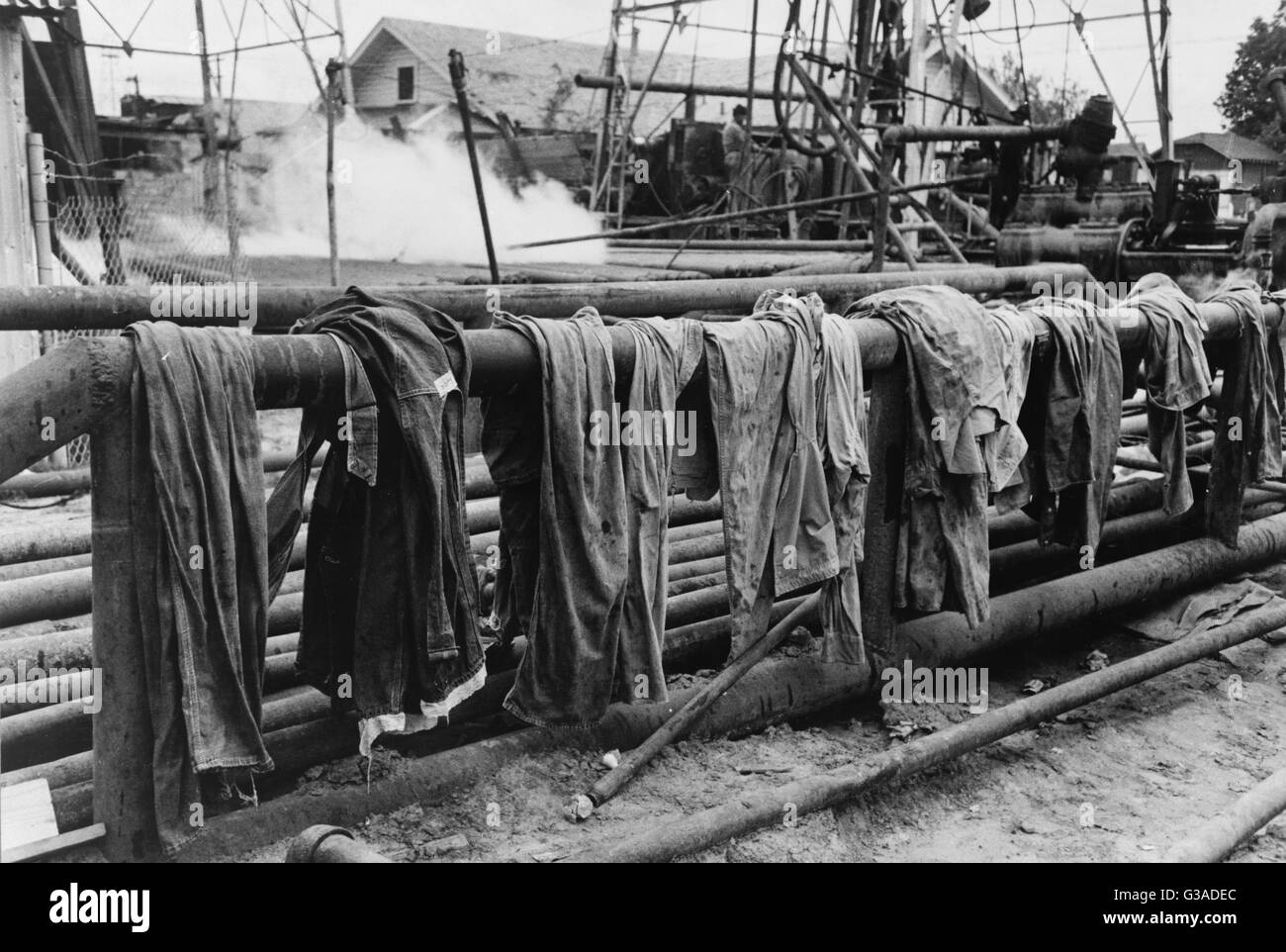 Clothing of oil drilling workers drying on steam pipe, Kilgore, Texas