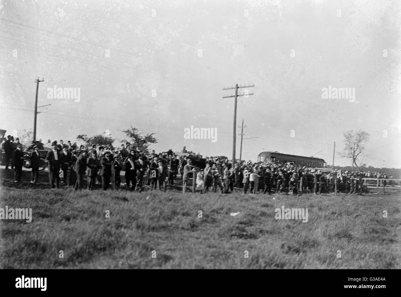 Large crowd of spectators gathered at the edge of a field at Stock Photo